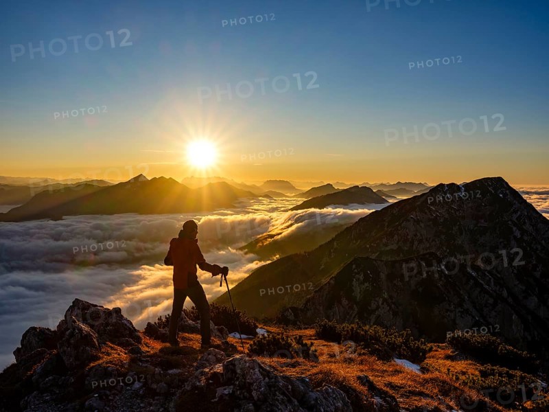 Mountaineer looking at alpine panorama at sunset, fog in the valley, Hochstaufen, Chiemgau Alps, Upper Bavaria, Bavaria, Germany