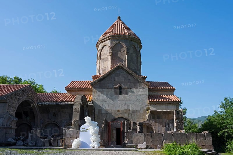 Historic church with tiled roof and blue sky in the background surrounded by greenery, Wahanavank Monastery, Syunik Province, Syunik, Armenia