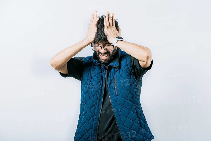 Unhappy man with headache concept. Painful man with a migraine holding his head isolated