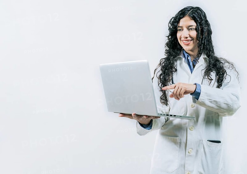Smiling Woman doctor using laptop on isolated background. Female young doctor using and pointing laptop isolated