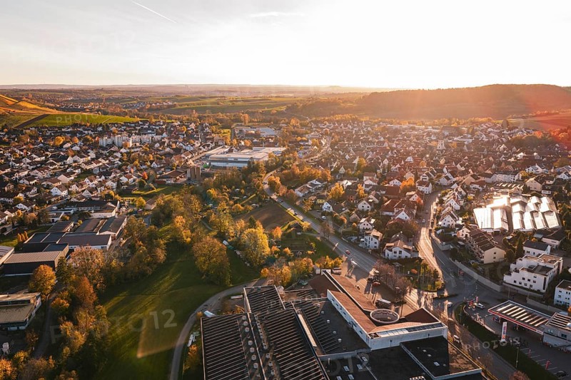 View over the rooftops of a city in autumn evening with lots of nature, Grossbottwar, Germany