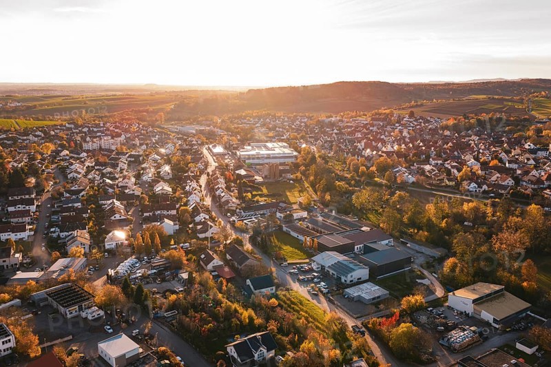 Extensive settlement surrounded by fields and trees in autumn at sunset, Großbottwar, Germany