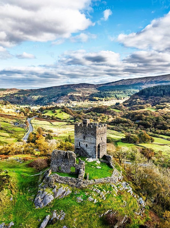 Autumn colours over Castell Dolwyddelan and Eryri Mountains from a drone, Snowdonia, Conwy County Borough, Wales, England, United Kingdom