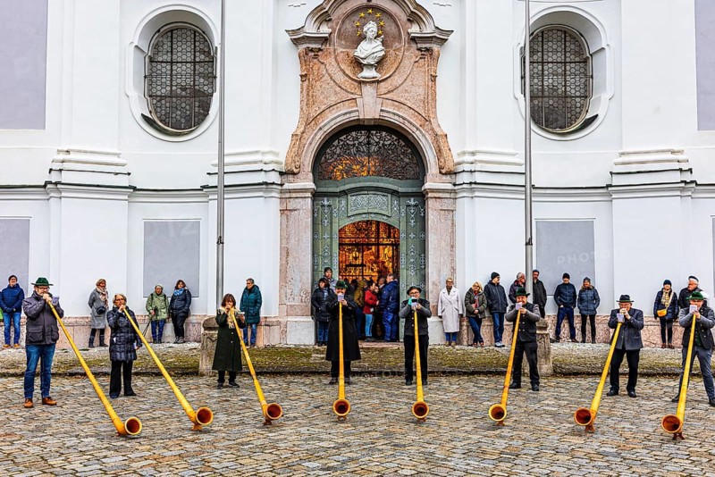 Alphorn group playing in front of Marienmünster in Dießen am Lake Ammer, Upper Bavaria, Bavaria, Germany