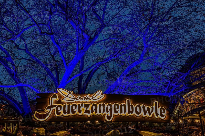 Sales stand for Feuerzangenbowle, above a deciduous tree illuminated with blue light, Christkindlmarkt, Rindermarkt, Munich, Upper Bavaria, Germany