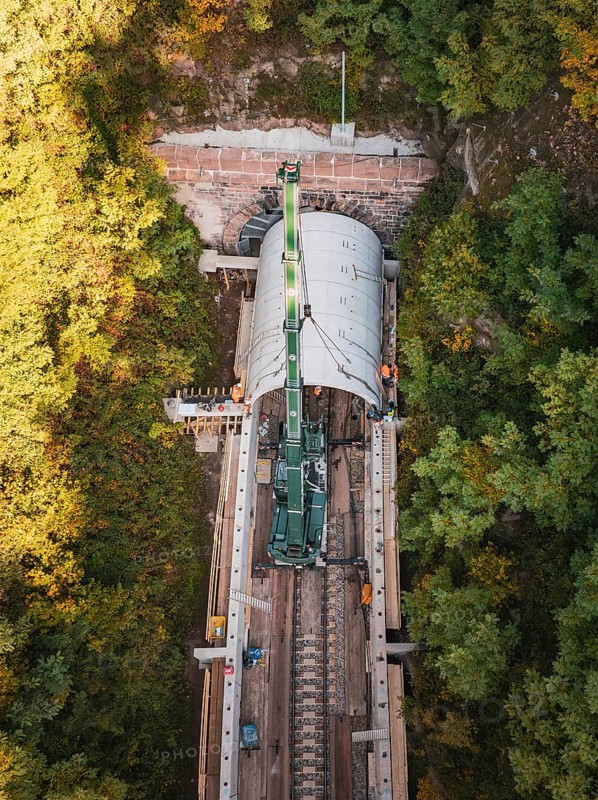 Drone photo of a crane working on a tunnel structure in an autumn environment, built by Hermann, Hesse, Bahn, Calw, Germany