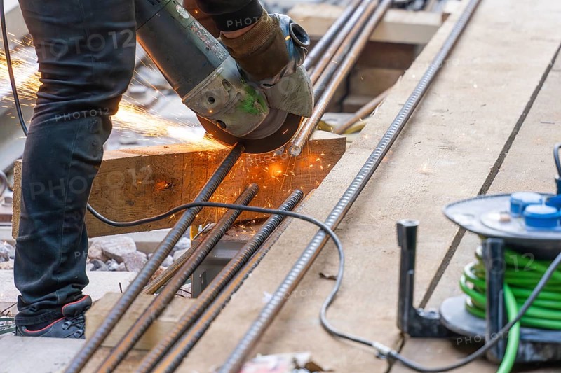 A construction worker cuts metal bars with a flex machine, Bau der Hermann, Hesse, Bahn, Calw, Germany