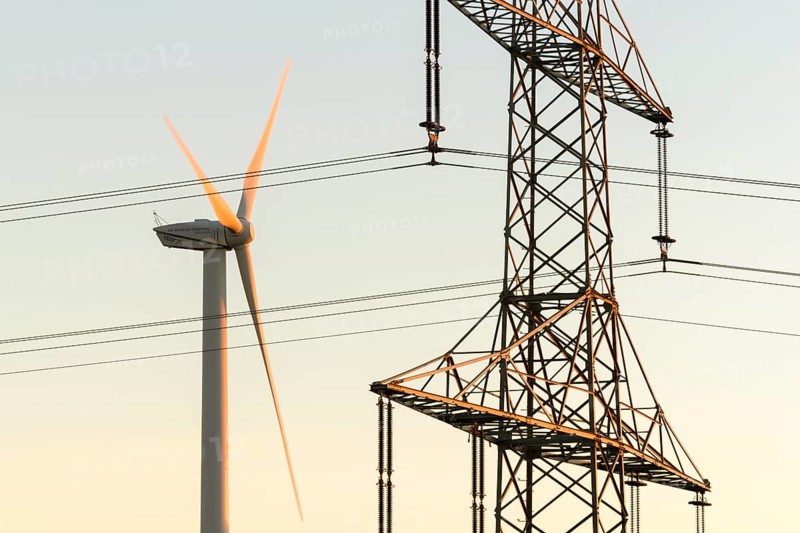 Wind turbine next to a power pole with wires, technical motif, Swabian Jura, Baden-Württemberg, Germany
