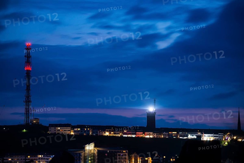 View of the highlands of the island of Heligoland at night with red-lit radio tower, radio tower, transmitter, bright lighthouse, dark church tower and deep blue sky with lots of clouds above, nighttime lowland in front of it, remnant of sunset in the night sky, quiet and dark atmosphere, cloud bank, weather, summer, night shot, long exposure, beacon, maritime, North Sea, Heligoland island, Pinneberg District, Schleswig-Holstein, Germany