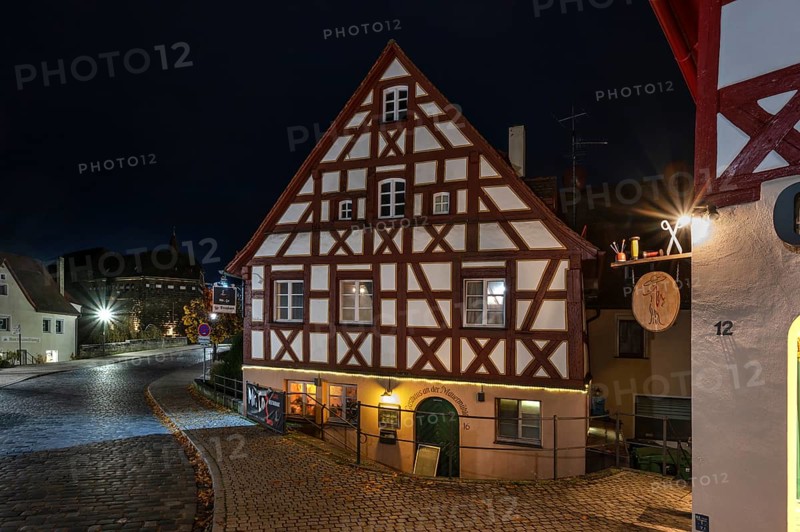 Night view of the historic half-timbered house, on the right the nose sign of a tailor shop, Lauf an der Pegnitz, Middle Franconia, Bavaria, Germany