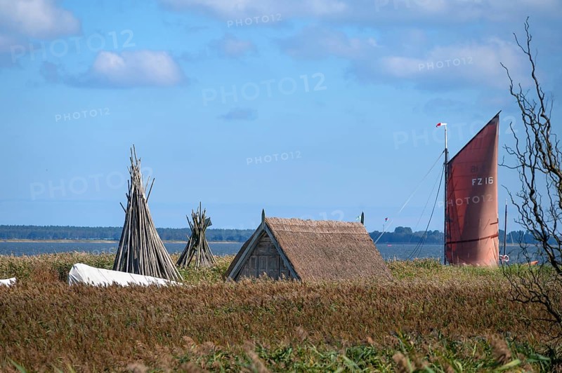 Zeesboot at a dock in the lagoon, fishing hut in the reed in front, Ahrenshoop, Darß, Mecklenburg-Western Pomerania, Germany