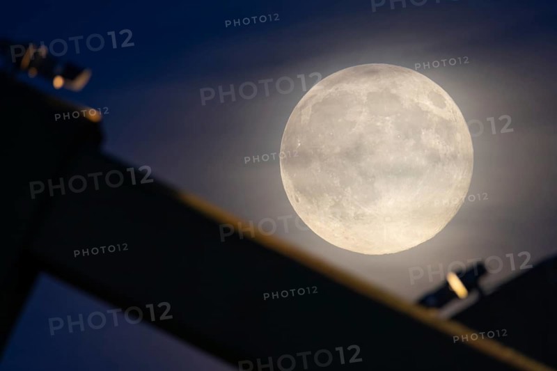 The full moon sweeps along the Frankfurt evening sky and passes the pillars of the rafter bridge, Frankfurt am Main, Hesse, Germany