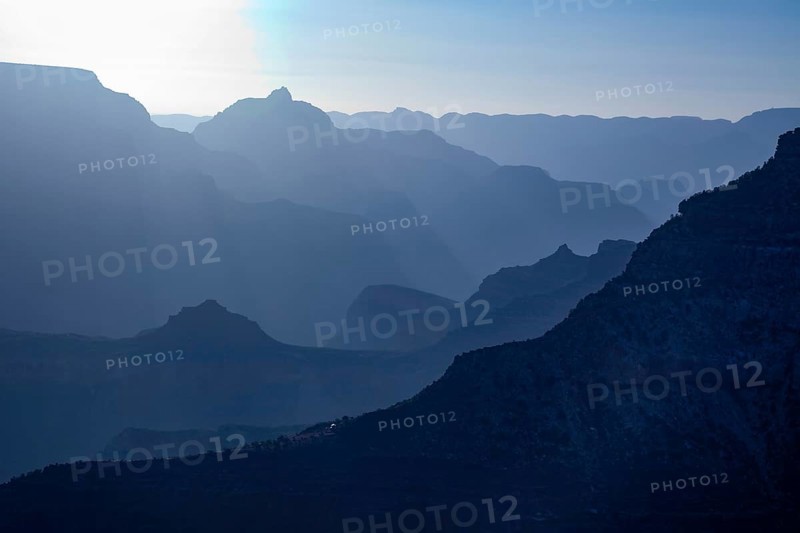 Scenic layers of the grand canyon in the early morning with hikers cabin roof shining in the lower middle