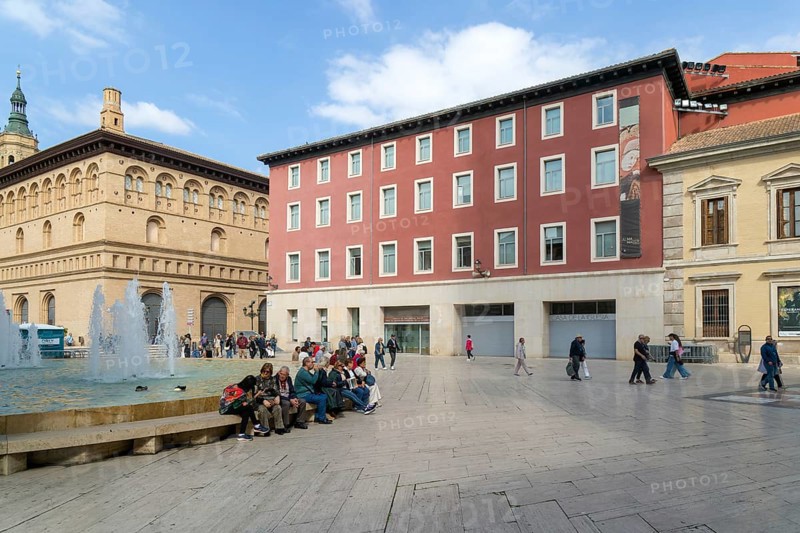 People sitting by fountain and historic buildings, Plaza la Seo, Zaragoza, Aragon, Spain