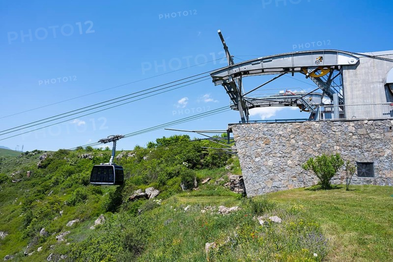 Cable car station with gondola in a green landscape, stone wall and bright blue sky, Tatev cable car, Wings of Tatev, Tatev wing, cable car station, Halidzor, Syunik province, Caucasus, Armenia