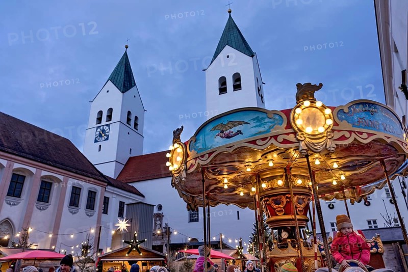 Illuminated old children's carousel, historic nostalgia carousel year 1888, Christmas market, courtyard on Domberg, Freising Cathedral St. Maria and St. Korbinian, bell towers, blue hour, Freising, Upper Bavaria, Bavaria, Germany
