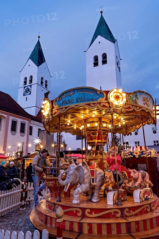 Illuminated old children's carousel, historic nostalgia carousel year 1888, Christmas market, courtyard on Domberg, Freising Cathedral St. Maria and St. Korbinian, bell towers, blue hour, Freising, Upper Bavaria, Bavaria, Germany