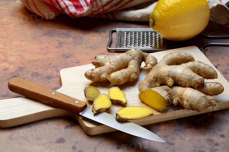 Ginger, ginger root cut with ginger slices on wooden boards