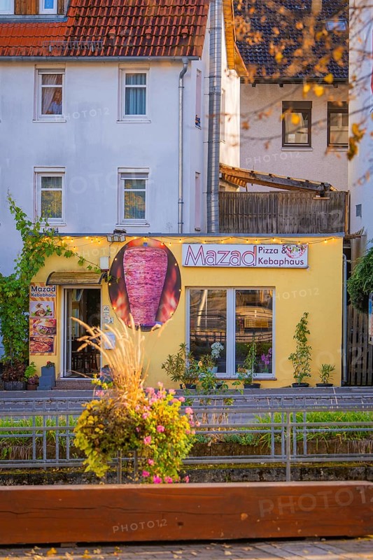 Small pizzeria with yellow façade in the midst of a colorful autumn backdrop, Aidlingen, Böblingen district, Germany