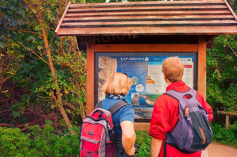Tourist couple in front of information board of Cape Arkona, coast of Rügen, largest German island, Baltic Sea coast of Western Pomerania, famous chalk cliffs, Mecklenburg-Western Pomerania, Germany