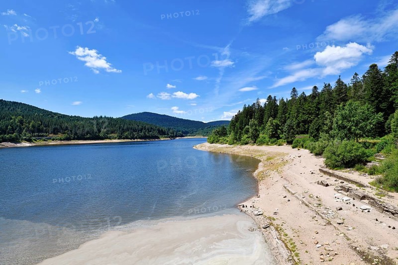 Beautiful mountain lake in the Black Forest in Forbach in Germany called Schwarzenbach Reservoir surrounded by forested hills under a clear sky