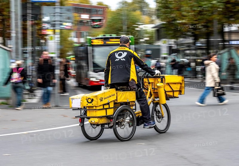 Delivery agent, Deutsche Post mailman on e-bike, Bochum, North Rhine-Westphalia, Germany