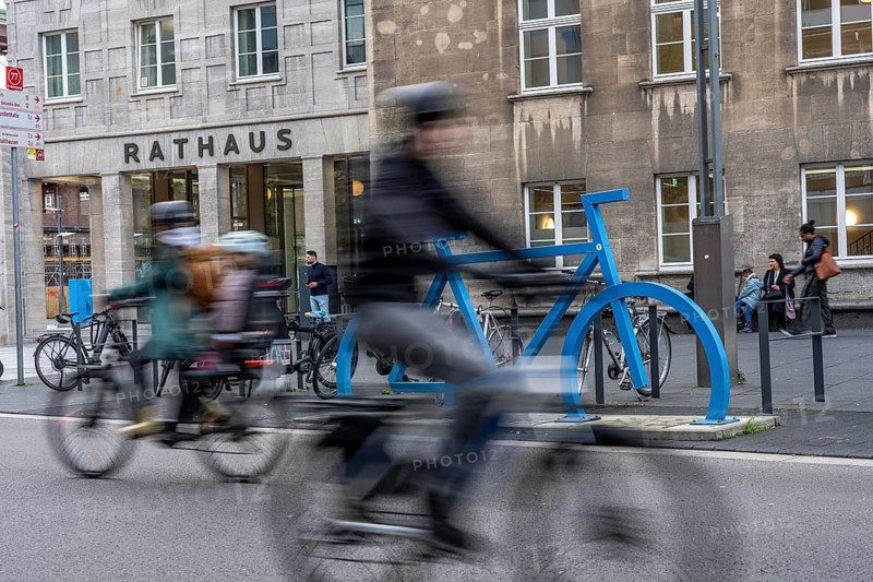 Bicycle parking spaces, with so-called leaning bars and a large blue bicycle silhouette, to make parking spaces visible at Bochum City Hall, North Rhine-Westphalia, Germany