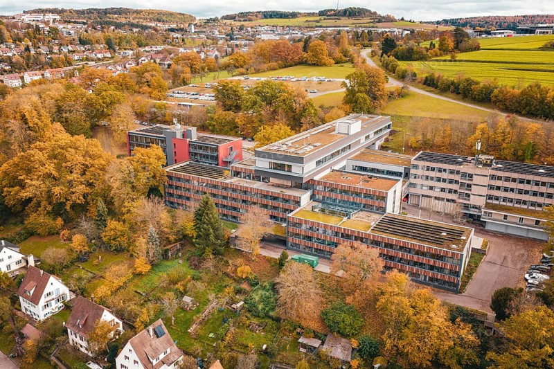 Multi-storey building complex with colorful autumn trees in rural surroundings, Calw District Office, Calw, Germany