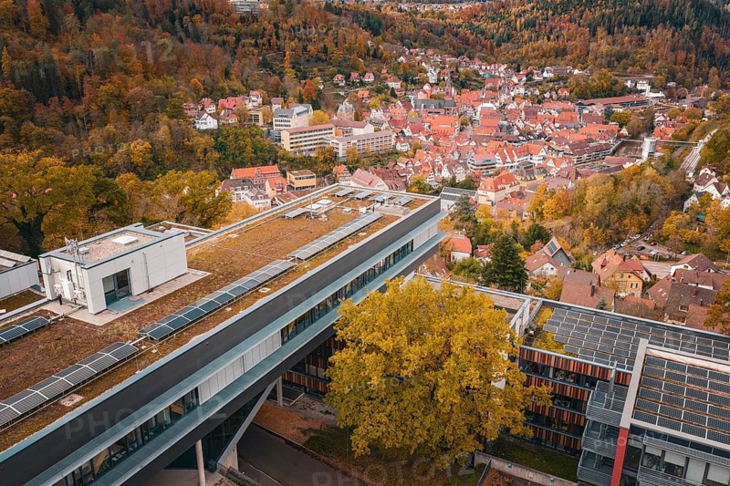 View of a modern building with tiled roofs and surrounding autumn landscape, Calw District Office, Calw, Germany