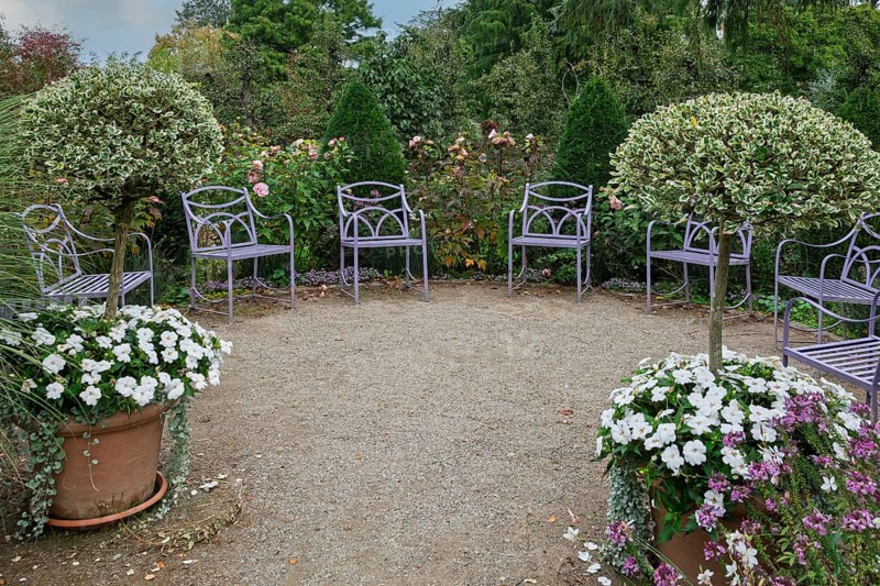 Quiet garden with purple chairs, surrounded by trees and flowering plants, Kreislehrgarten Burgsteinfurt, Münsterland, North Rhine-Westphalia, Germany