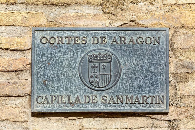 Sign for Cortes de Aragon, Capilla de San Martín, courtyard chapel of Saint Martin, Aljafería Palace, Zaragoza, Aragon, Spain