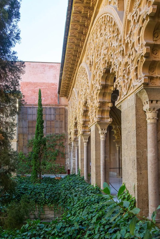 Ornate Islamic design decorated Moorish arches, courtyard garden of Santa Isabel, Aljafería Palace, Zaragoza, Aragon, Spain