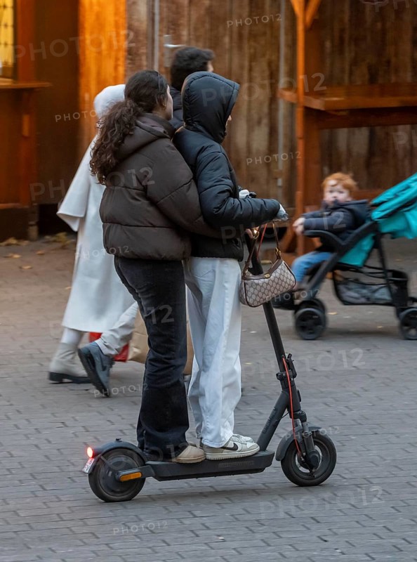 City center, shopping street, Kettwiger Straße pedestrian zone in Essen, 2 young woman on an e-scooter, electric scooter, in front of the opening of the Christmas market, North Rhine-Westphalia, Germany