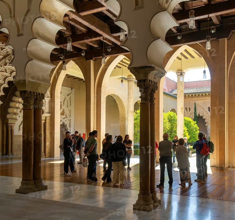 Tour group tourists viewing Moorish arches, Aljafería Palace, Zaragoza, Aragon, Spain