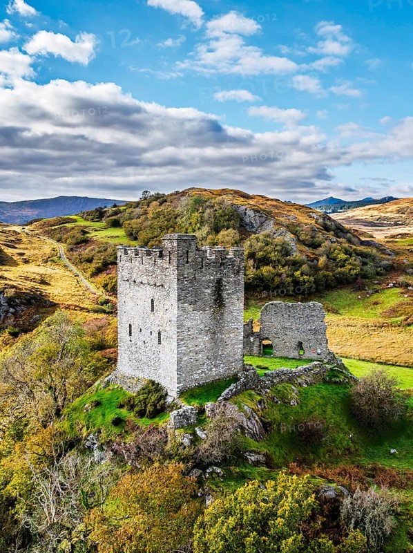 Autumn colours over Castell Dolwyddelan and Eryri Mountains from a drone, Snowdonia, Conwy County Borough, Wales, England, United Kingdom