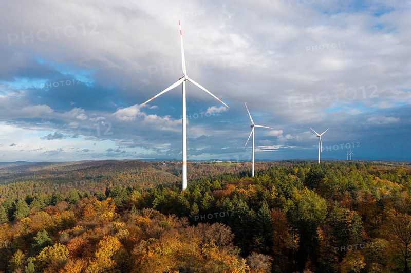 Wind turbines stand in a colorful autumn forest under a changing sky, near Schorndorf, Remstal, Rems-Murr-Kreis, Baden-Württemberg, Germany
