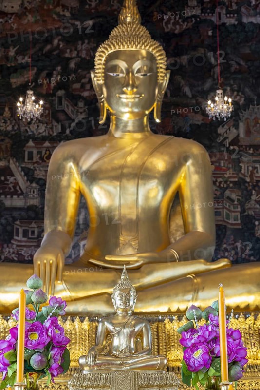 Golden Buddha statue, Phra Buddha Trilokachet surrounded by crystal chandeliers and exquisite wall paintings, interior view of Phra Ubosot or ordination hall, Wat Suthat Thepwararam, Royal Temple, Phra Nakhon, Bangkok, Thailand