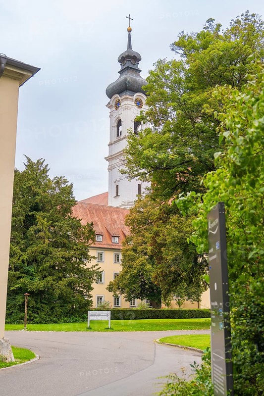 Baroque church tower behind trees and building complex in a green landscape, ZFP Zwiefalten, Reutlingen district, Germany