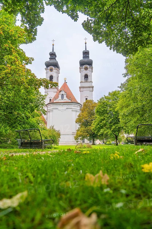 View of a church with two towers surrounded by lush green trees and well-kept lawn, ZFP Zwiefalten, Reutlingen district, Germany