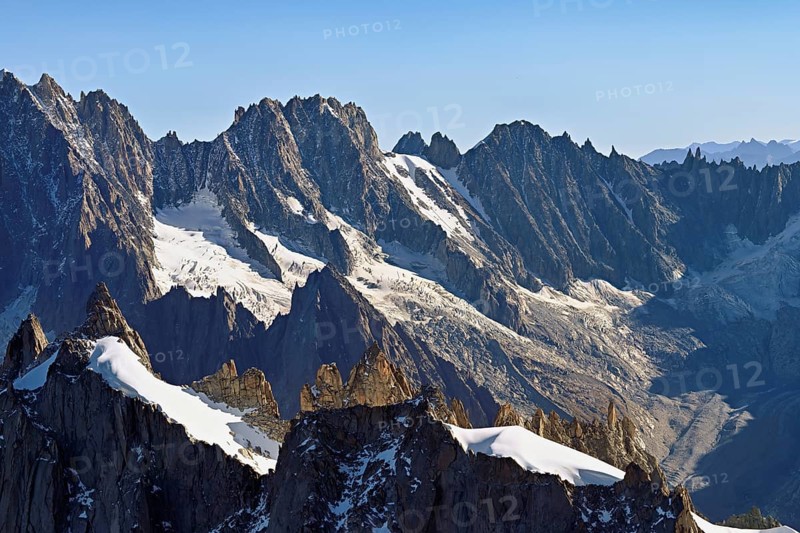 Rugged rocks jut out of a snow-covered mountain, viewing platform, Aiguille du Midi mountain station, Chamonix-Mont-Blanc, Haute-Savoie, France