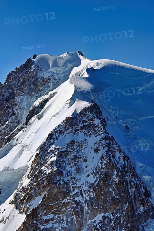 A group of mountaineers runs across a snow-covered mountain, Aiguille du Midi, Chamonix-Mont-Blanc, Haute-Savoie, France