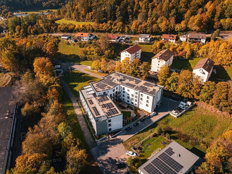 Aerial view of an autumnal residential area with solar panels and surrounding trees, Nagold, Black Forest, Germany