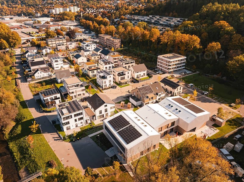 A residential area with modern houses and solar panels, surrounded by autumn trees, Nagold, Black Forest, Germany