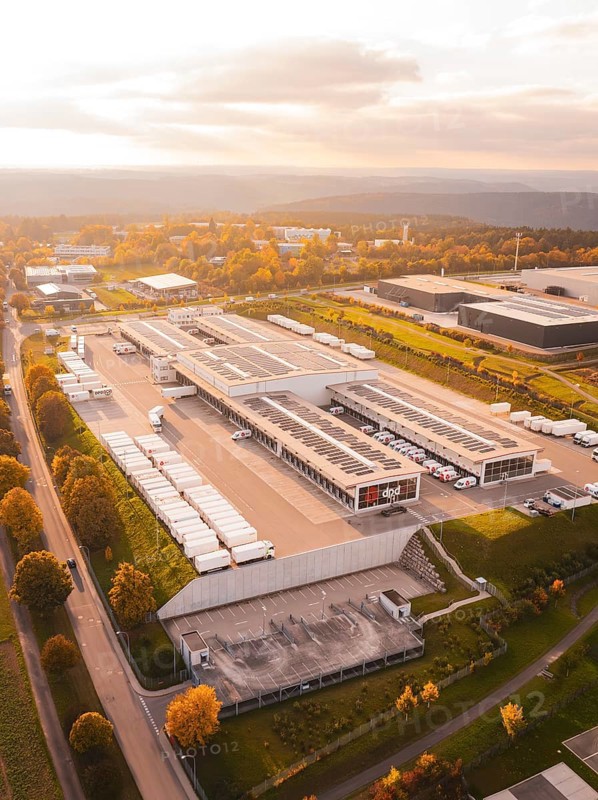 Extensive industrial park with parked trucks and buildings, in colorful late afternoon light, Nagold, Black Forest, Germany