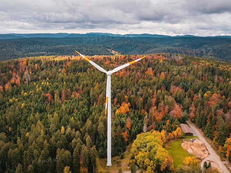 Wind turbines in autumn forest surrounded by clouds and roads, Simmersfeld wind farm, Germany