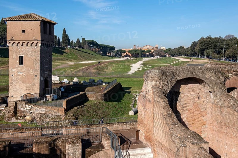 View of location from in the foreground ruins of former stands around south bend of on Circus Maximus venue of chariot races, left medieval tower Torre della Moletta, part of medieval building ruin from the Middle Ages in the archaeological complex of Circus Maximus, Rome, Lazio, Italy
