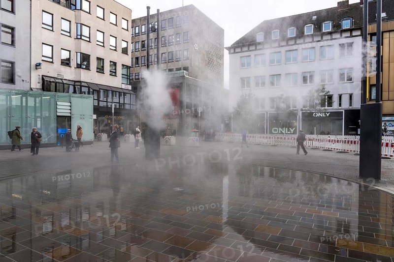 Digital water feature, Blue Cloud water installation on Husemanplatz in downtown Bochum, water mist is sprayed from 4 metal masts, which, in conjunction with the circular water surface, is intended to cool the surrounding area when it is hot, colored light images are projected into the water mist via projectors, part of the transformation of Husemanplatz