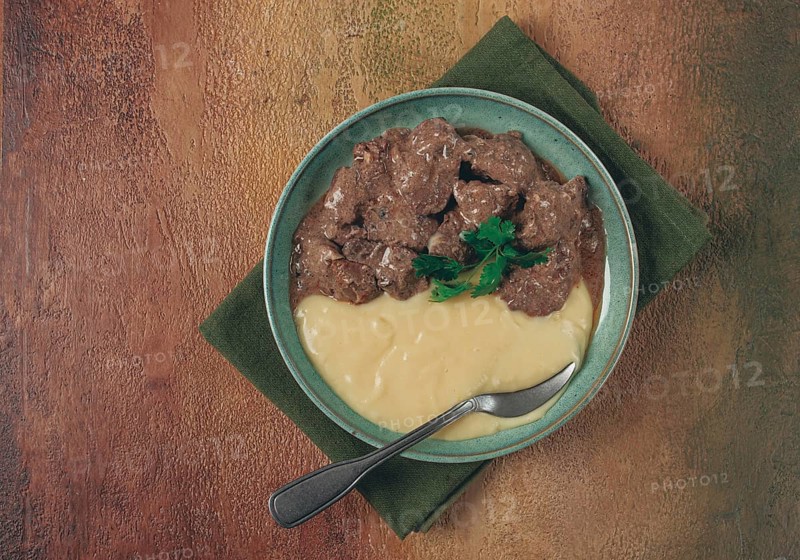 Liver beef stroganoff with mashed potatoes, table setting in green tones, homemade