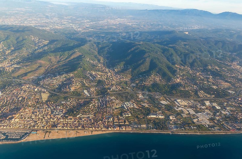 Oblique aerial view of settlements on coastal plain and hillsides, Mediterranean Sea coast, El Masnou, Barcelona, Catalonia, Spain
