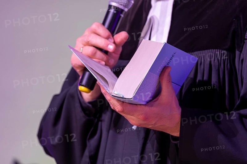 Protestant priest holding a Bible (church symbol)